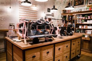 Sanremo Café Racer espresso machine in custom pink finish showcased in a cozy, boutique-style café — perfect for coffee shop owners looking to combine high-end performance with inviting, Instagram-worthy interiors.