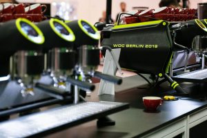Custom Sanremo Café Racer espresso machines with neon green accents on display at WOC Berlin 2019 — a standout choice for cafés wanting professional performance with bold, event-inspired customization.