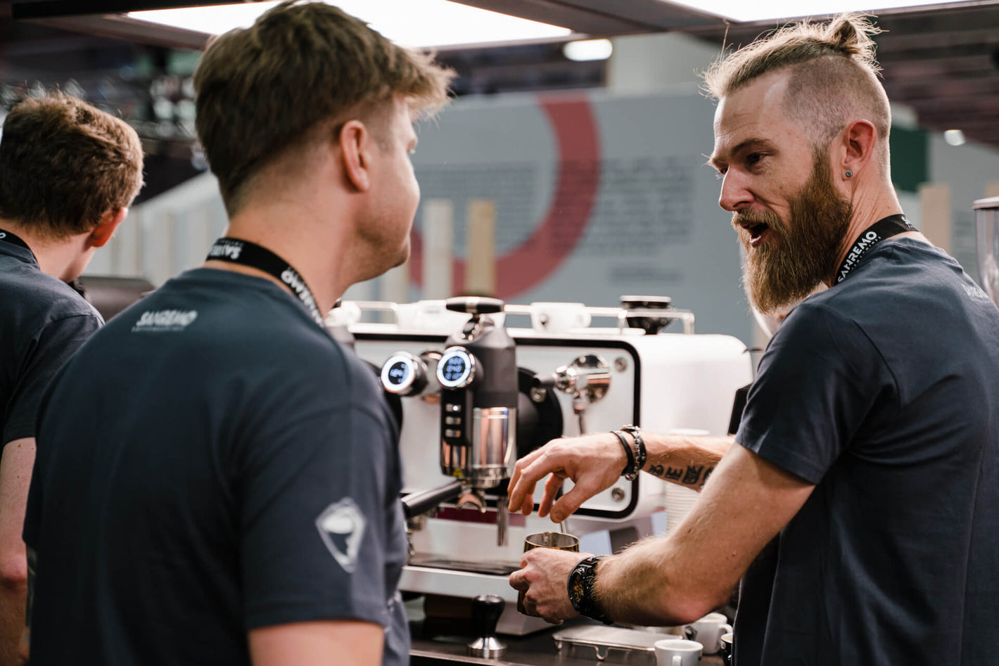 Sanremo team presenting Opera 2.0 espresso machine in white at industry event