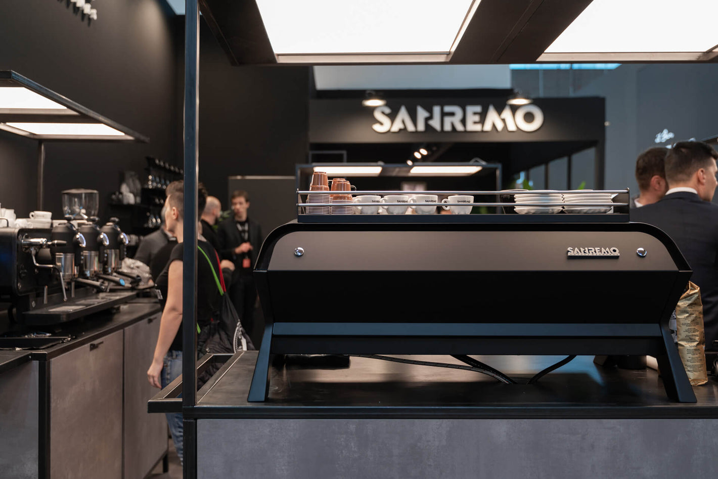 Sanremo F18 3 groups black commercial espresso machine rear view, at a Sanremo booth at a coffee industry event