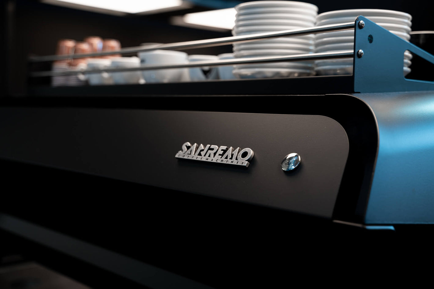 Sanremo F18 black commercial espresso machine rear view logo close up, at a Sanremo booth at a coffee industry event