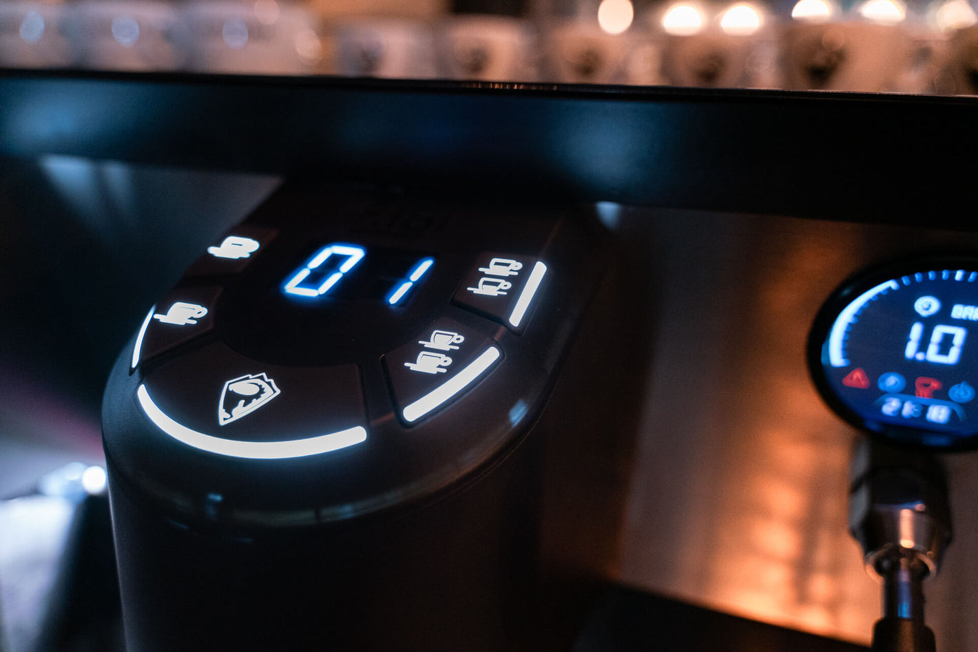 Sanremo F18 commercial espresso machine, close-up of the group head display lit up at the cafe bar with warm lighting