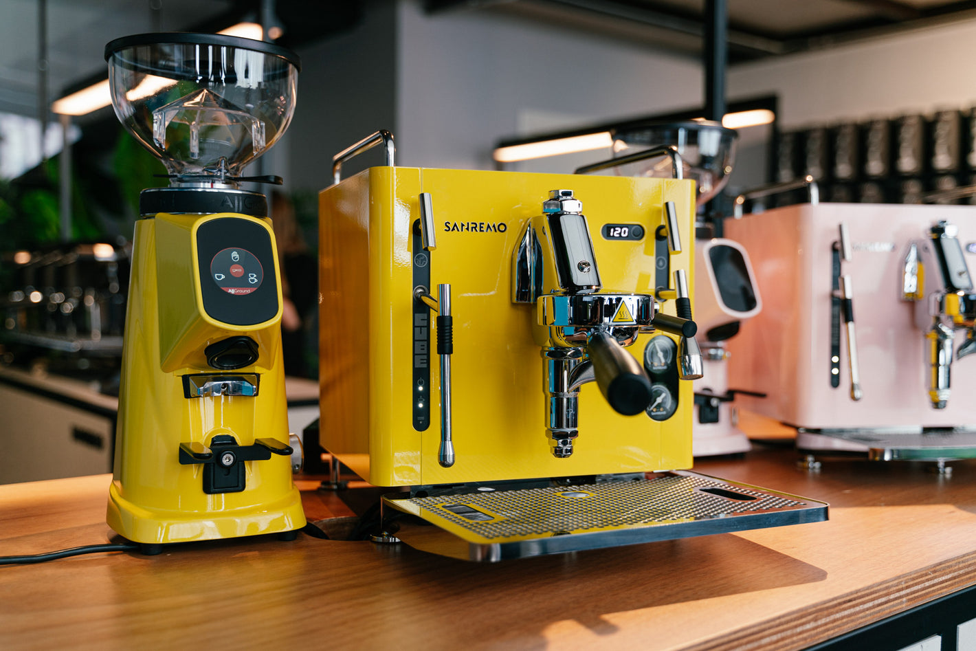 Sanremo CUBE espresso machines combined with Sanremo Allground grinders in yellow and pink for home baristas